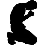Muž klečí v modlitbě silueta